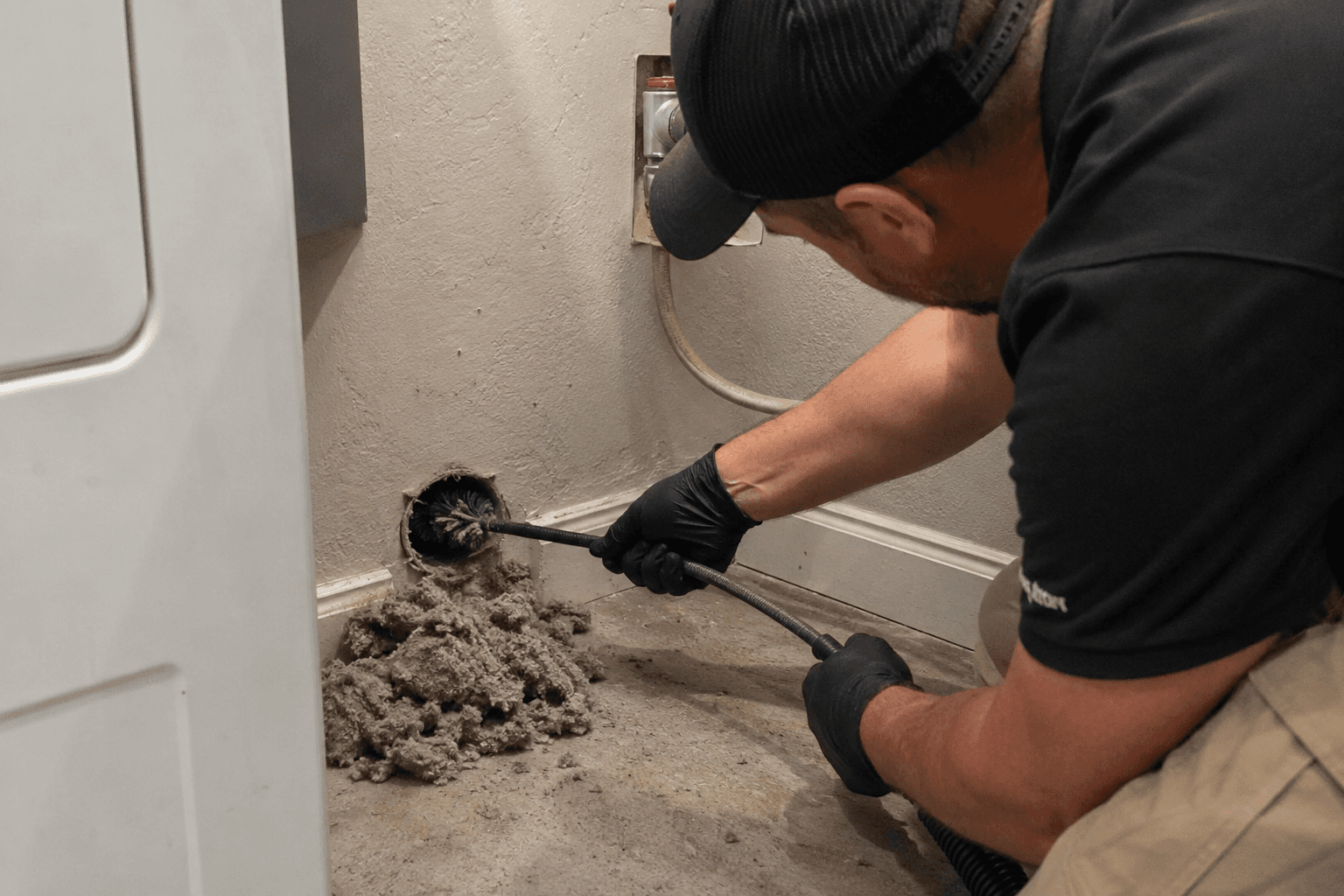 Technician professionally cleaning a dryer vent
